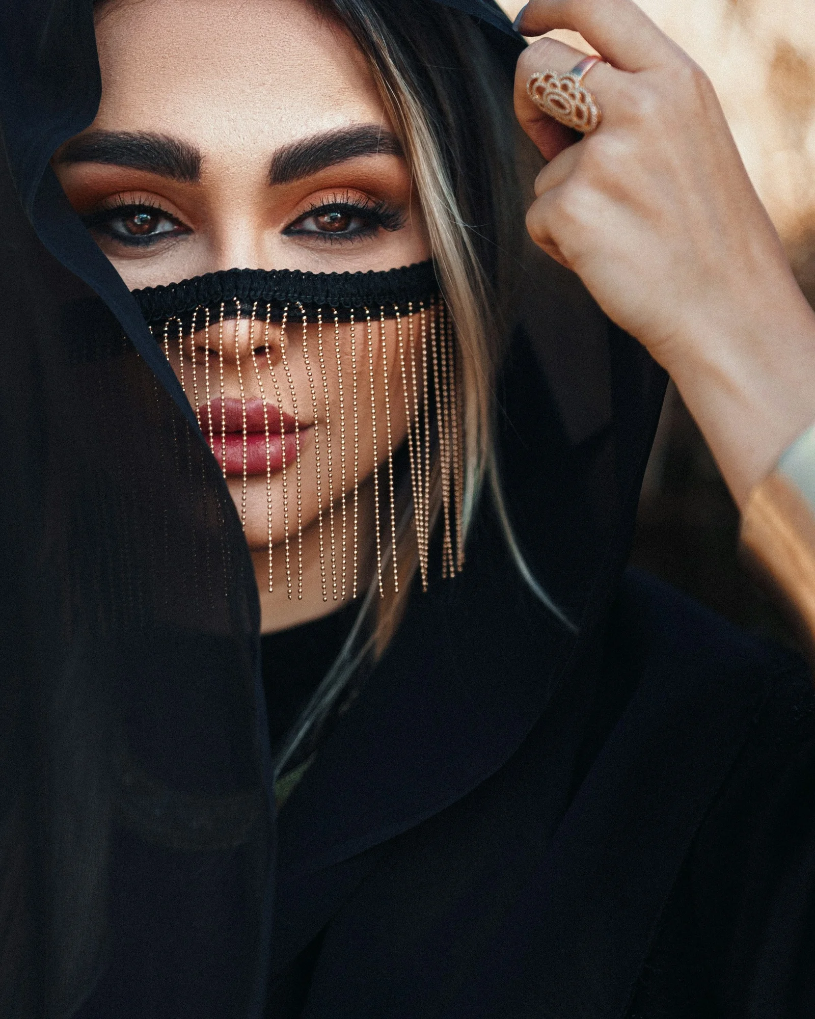 a woman wearing a black veil and a ring