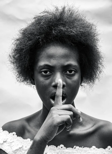 a black and white photo of a woman making a finger sign