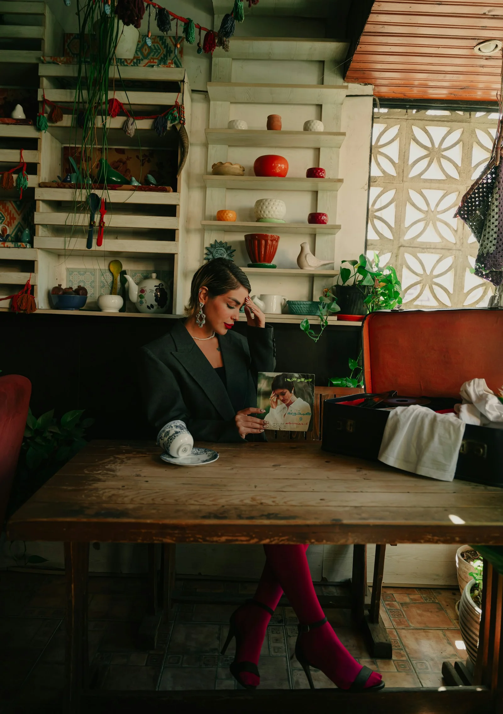 A woman sits and reflects at a wooden table