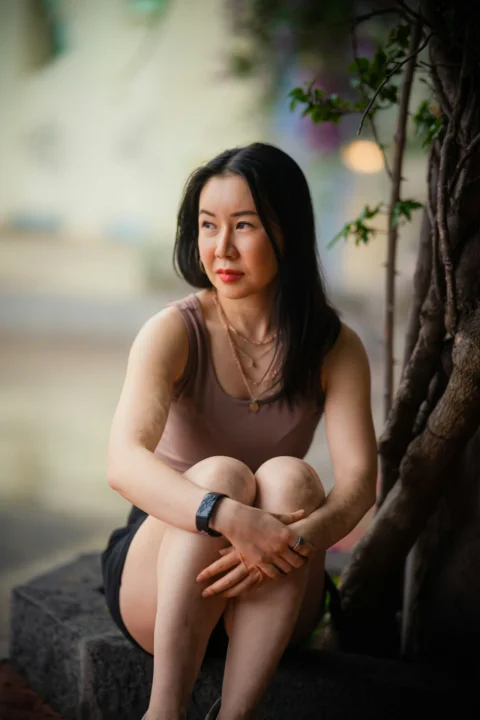 一个坐在树旁岩石上的女人