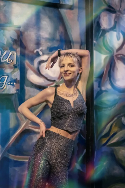 a woman posing for a picture in front of a mural