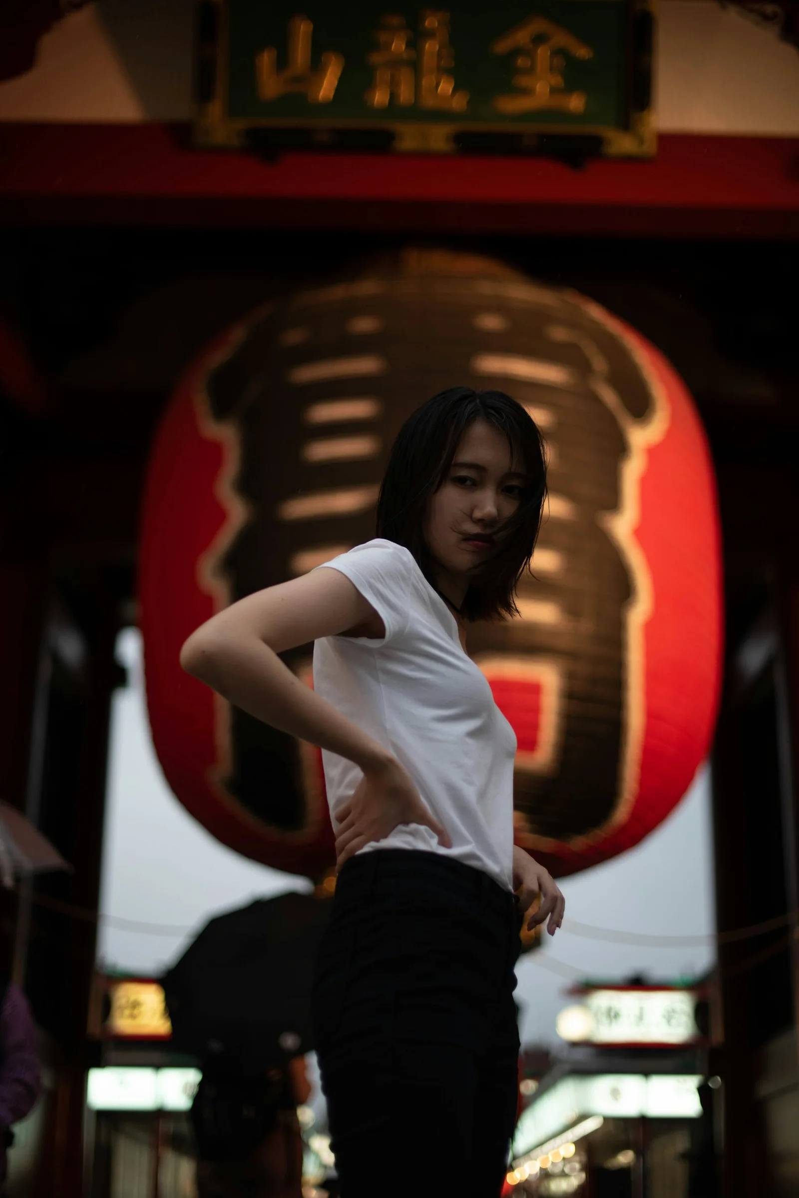 a woman standing in front of a red sign