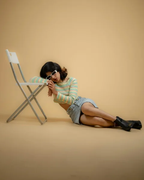 a woman sitting on the ground next to a chair