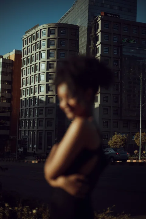 a woman standing in front of a tall building