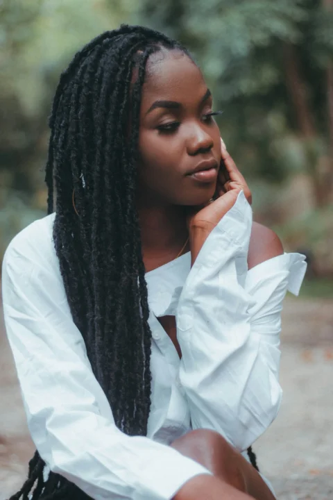 a woman sitting on the ground wearing a white shirt