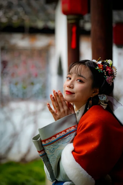 穿着红色大衣、头发上别着花朵的女人