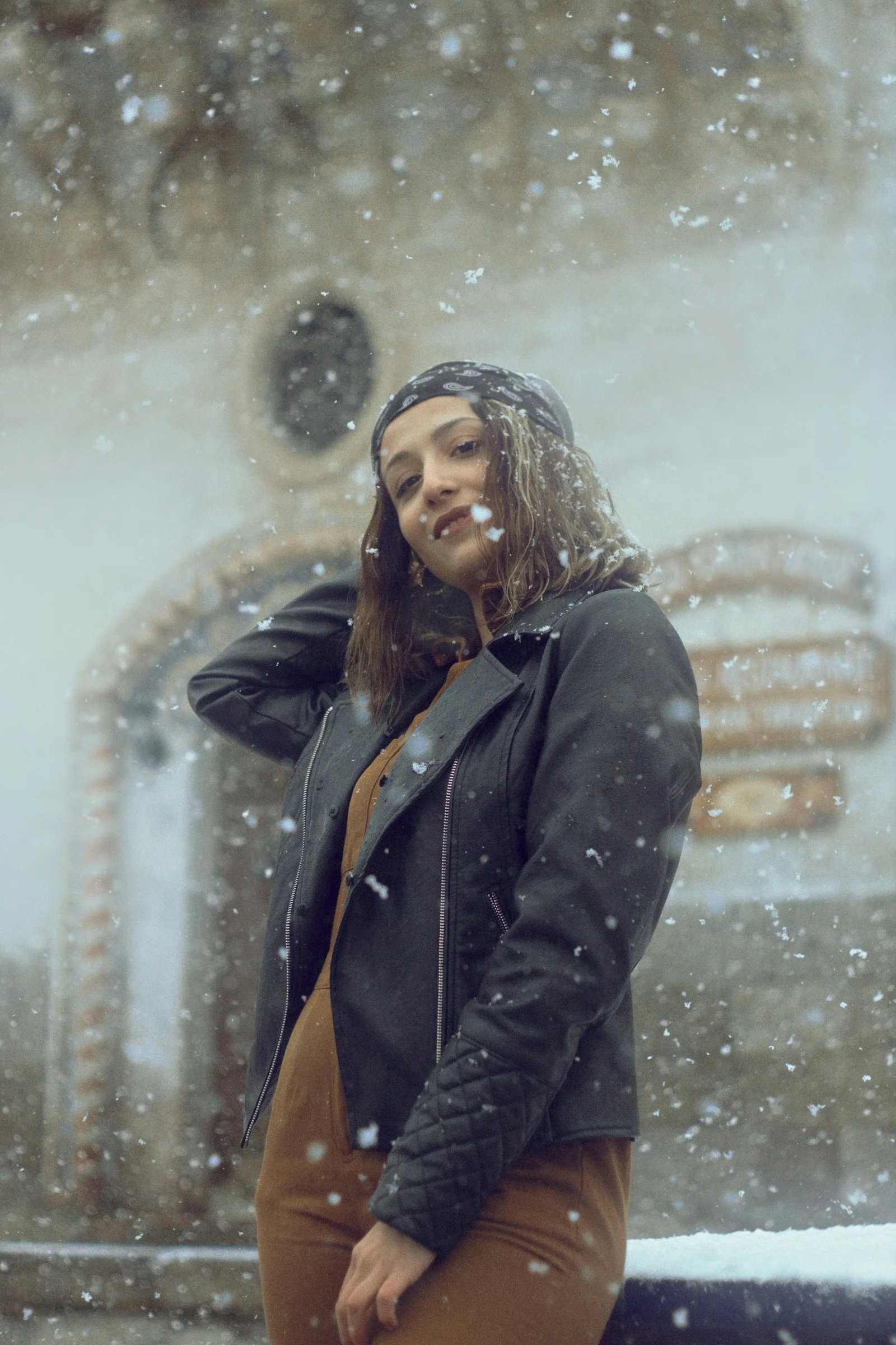 雪の中、建物の前に立っている女性