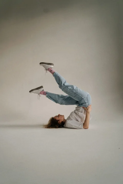 a woman is doing a handstand on her feet