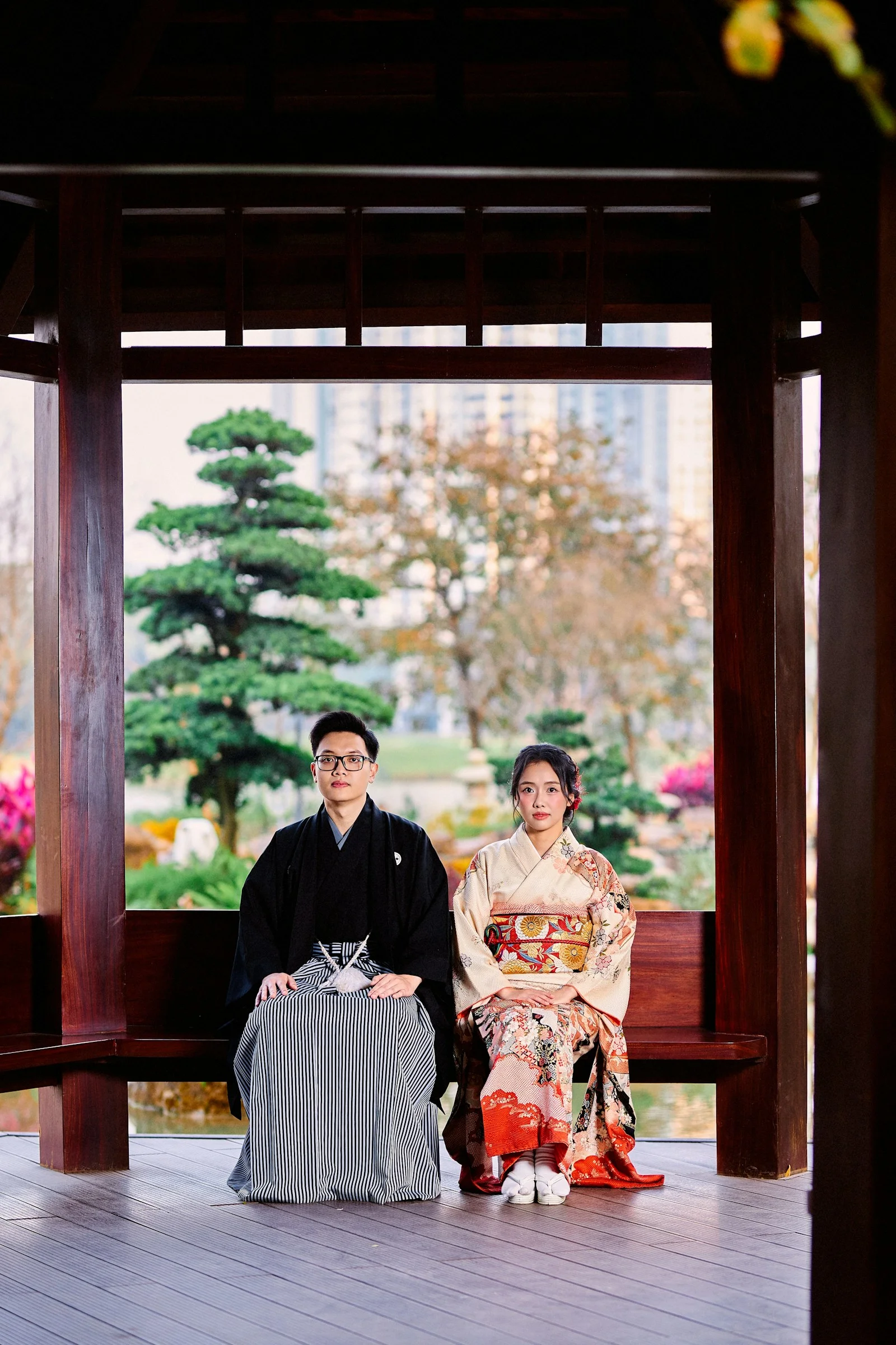 Couple in traditional japanese kimonos sitting on a wooden bench