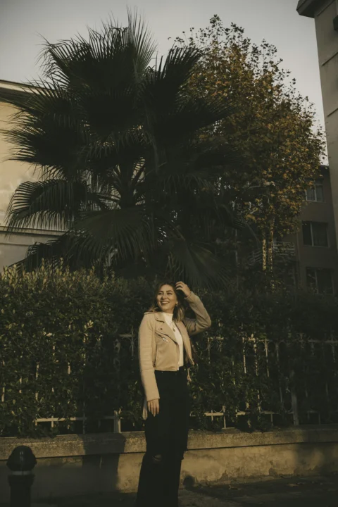 a woman standing in front of a palm tree