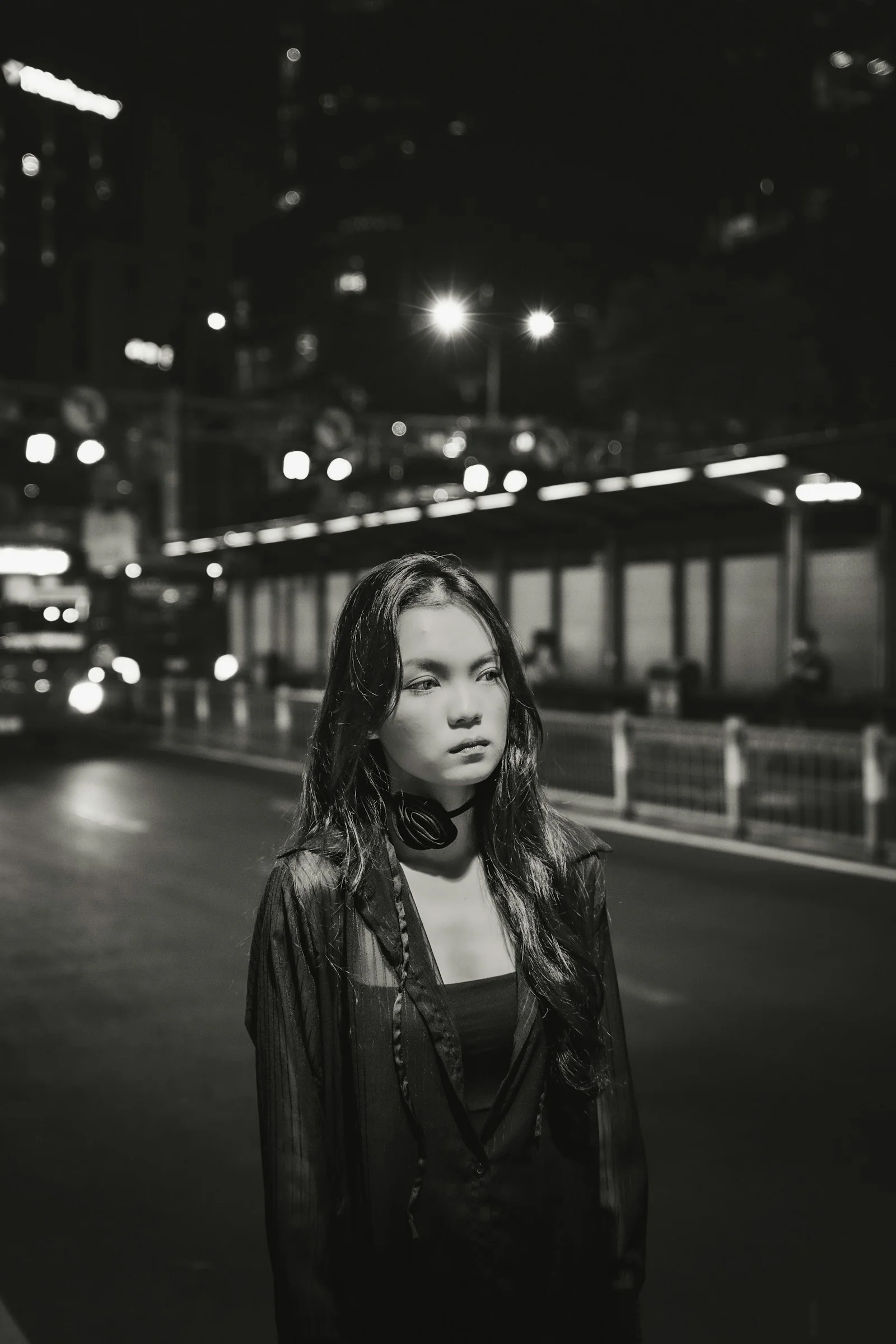 a woman standing on the side of a road at night