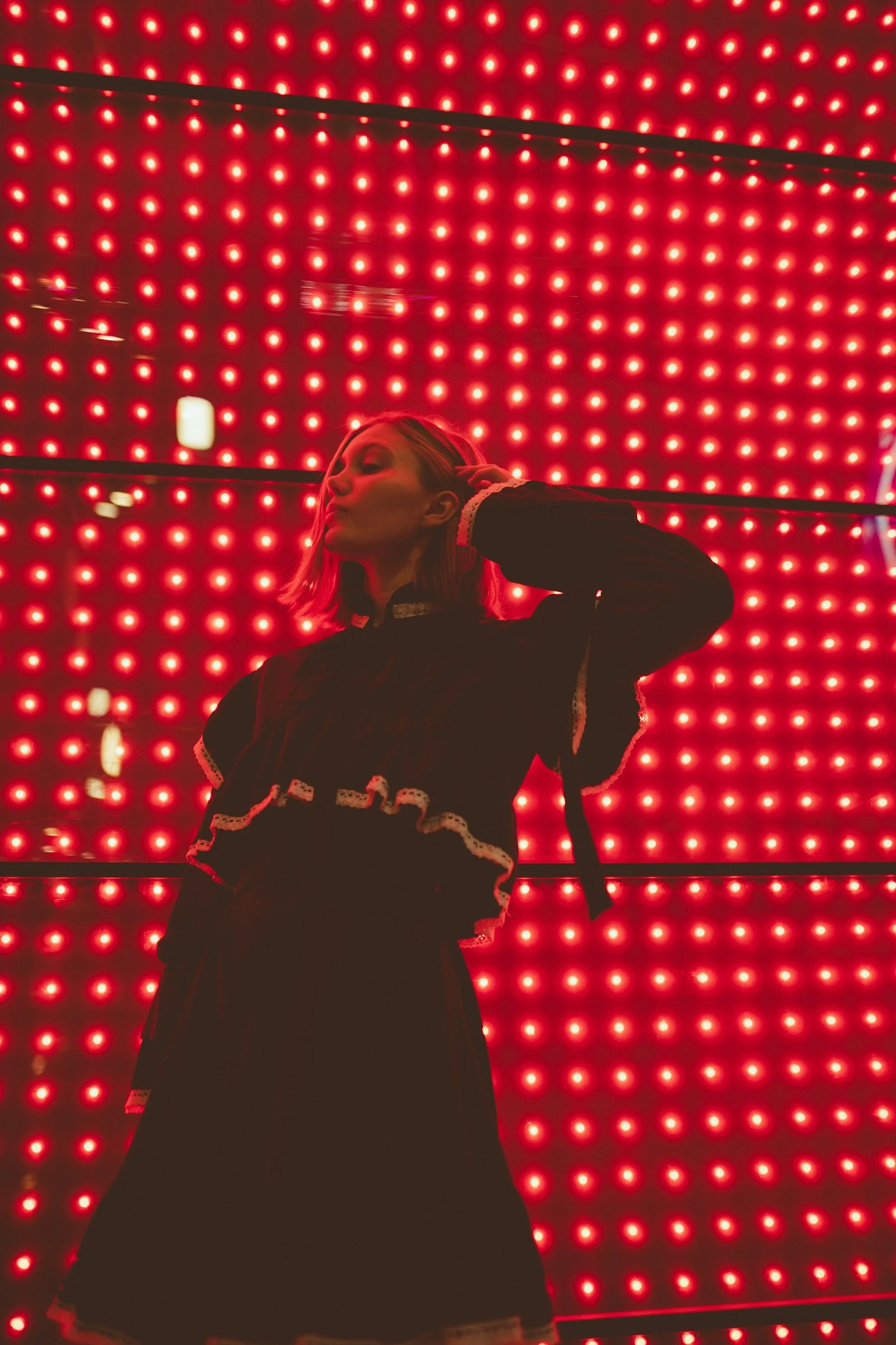 a woman standing in front of a red light