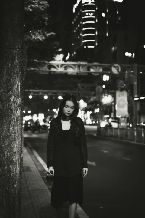 a woman walking down a street at night