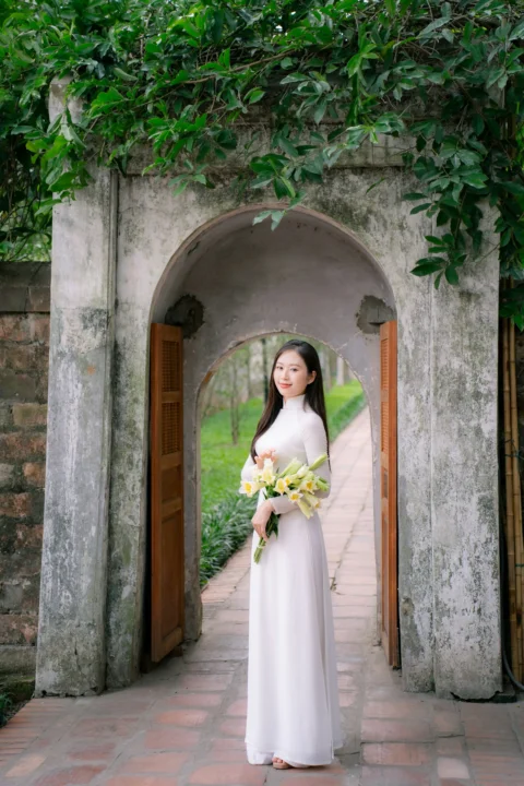 Woman poses in traditional clothing with flowers