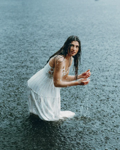 Woman stands in the rain, embracing it