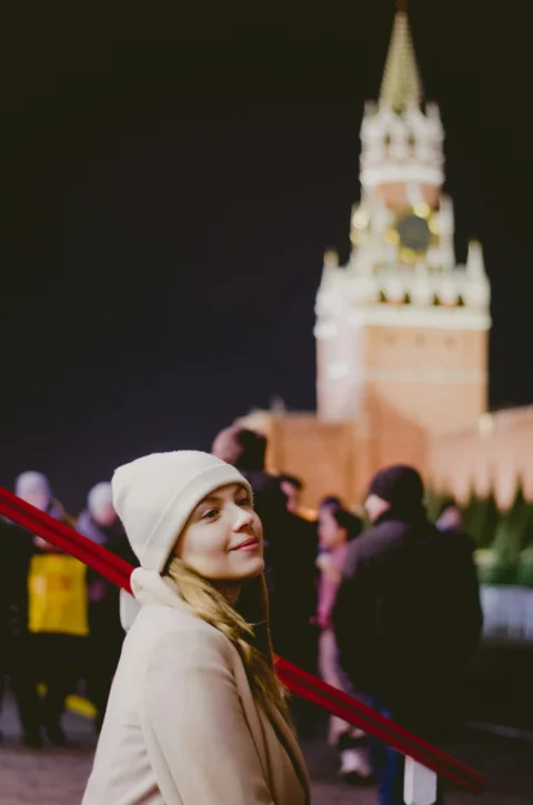 a woman standing in front of a clock tower
