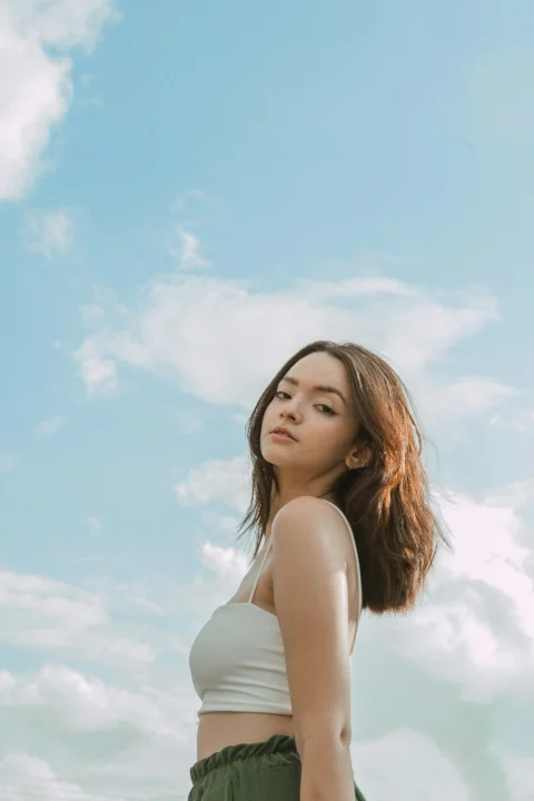 a woman standing in front of a blue sky
