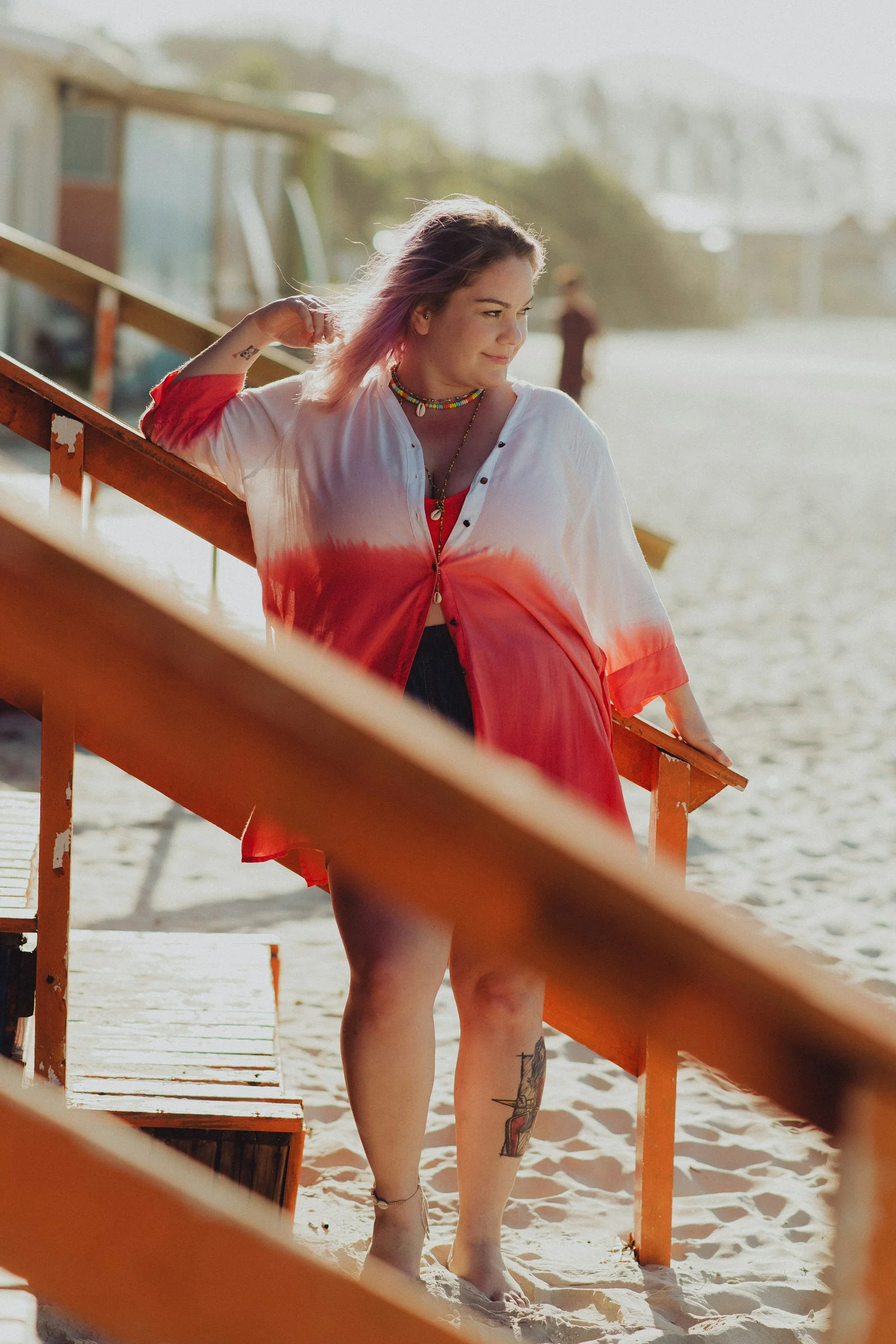 a woman in a red and white dress standing on a beach