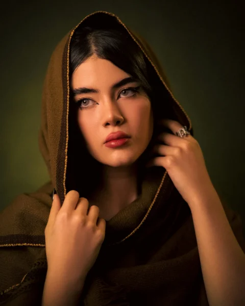 A woman wearing a brown hoodie with a ring on her finger