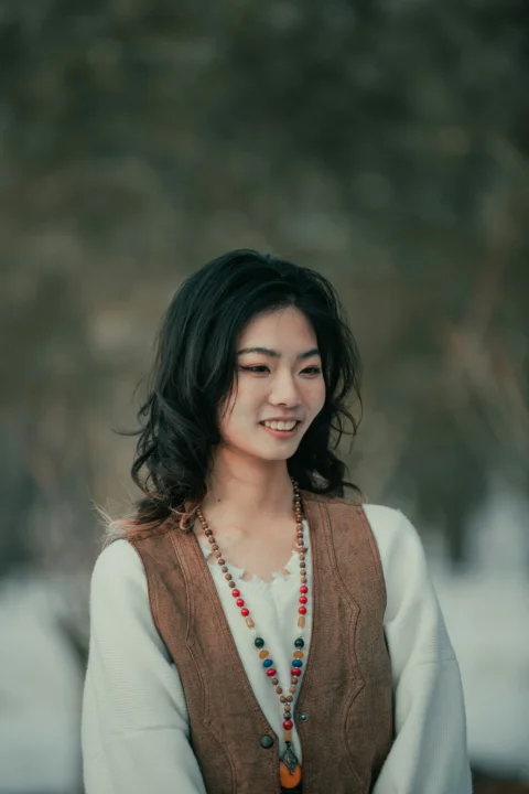 一位穿棕色背心、戴串珠项链的女子