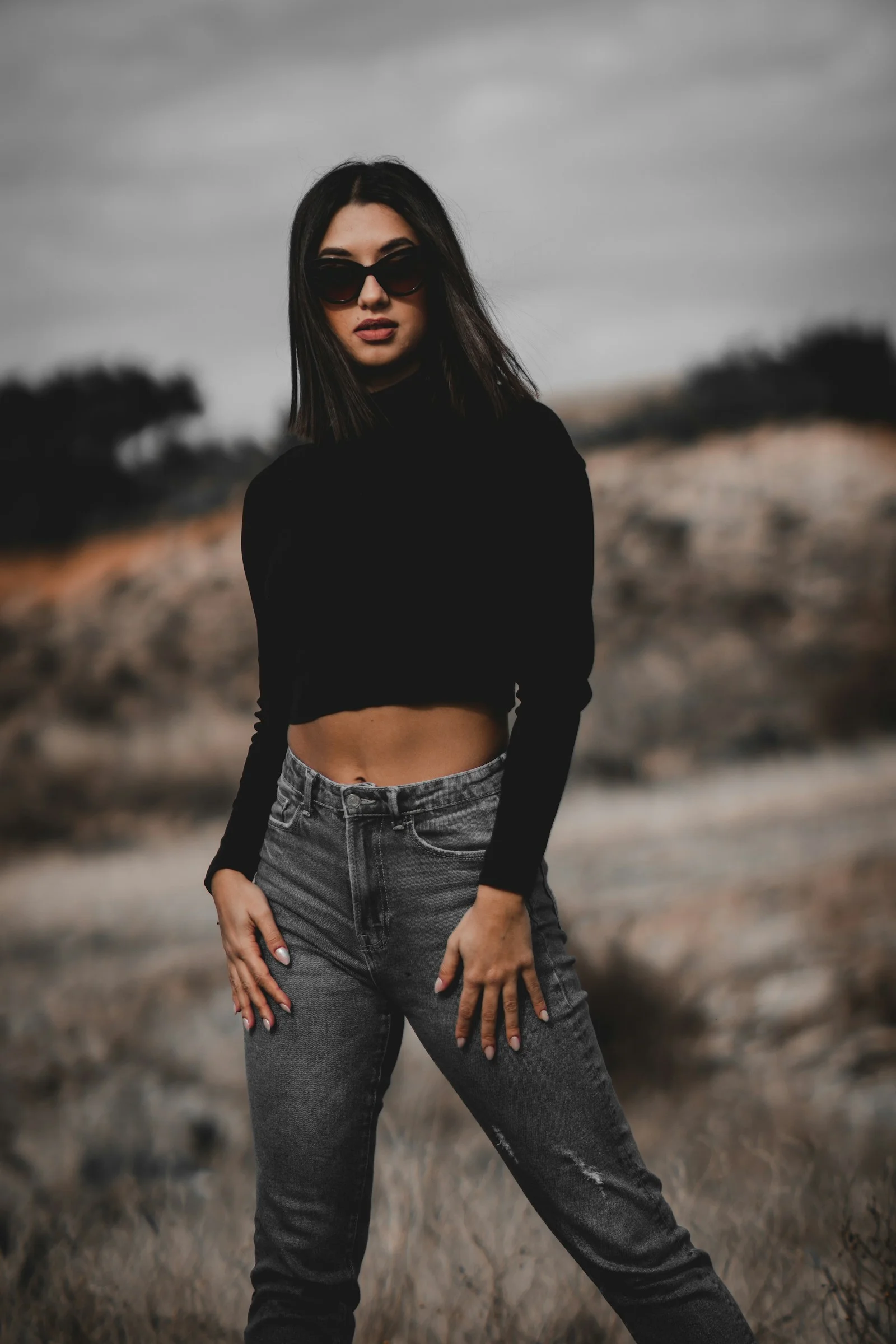 a woman in black shirt and jeans posing for a picture