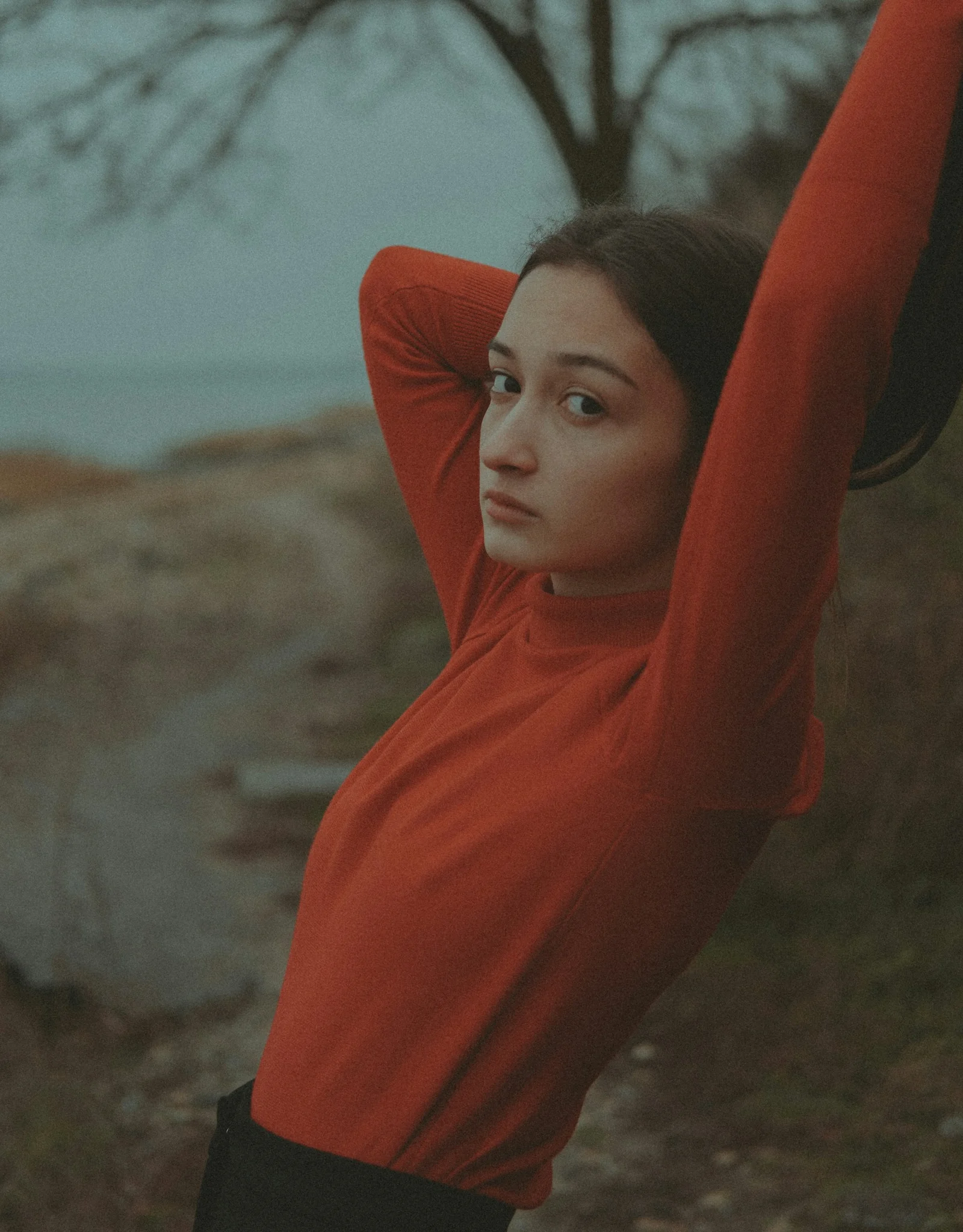 一名穿紅色襯衫的女子舉起雙臂