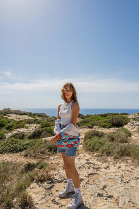 a woman standing on top of a sandy beach