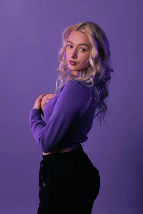 a woman in a purple shirt posing for a picture