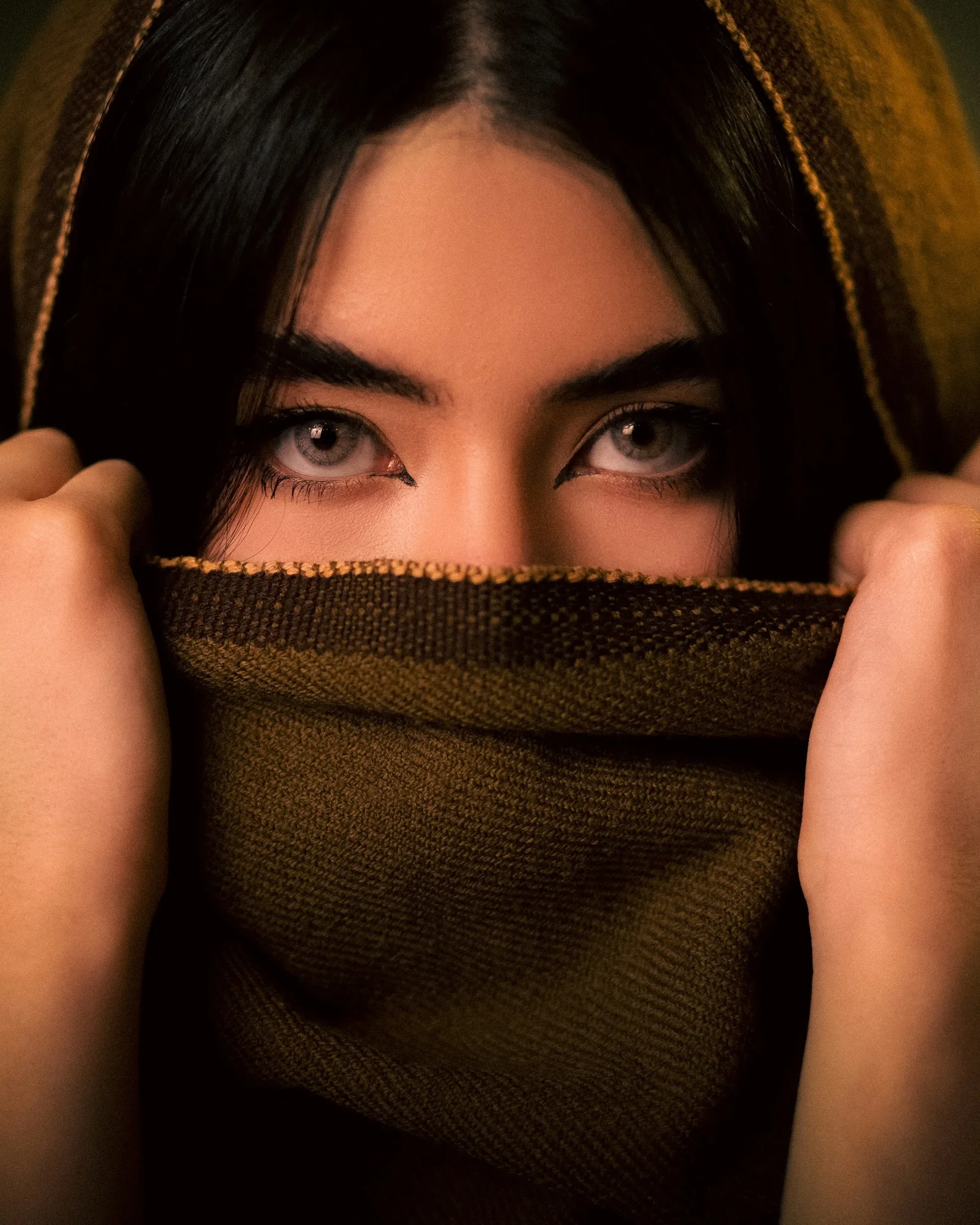 A woman covering her face with a scarf