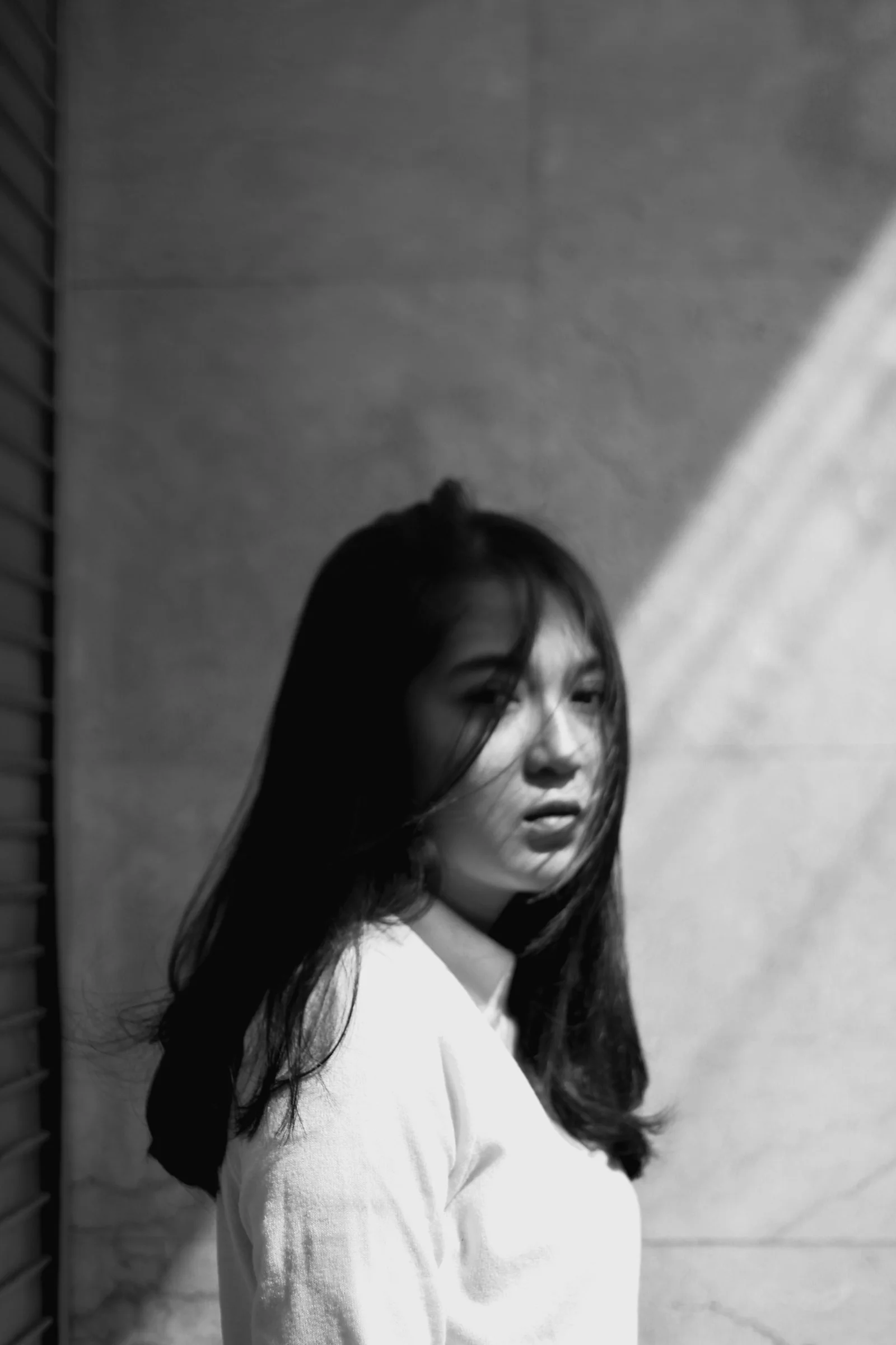 woman in white shirt standing near wall