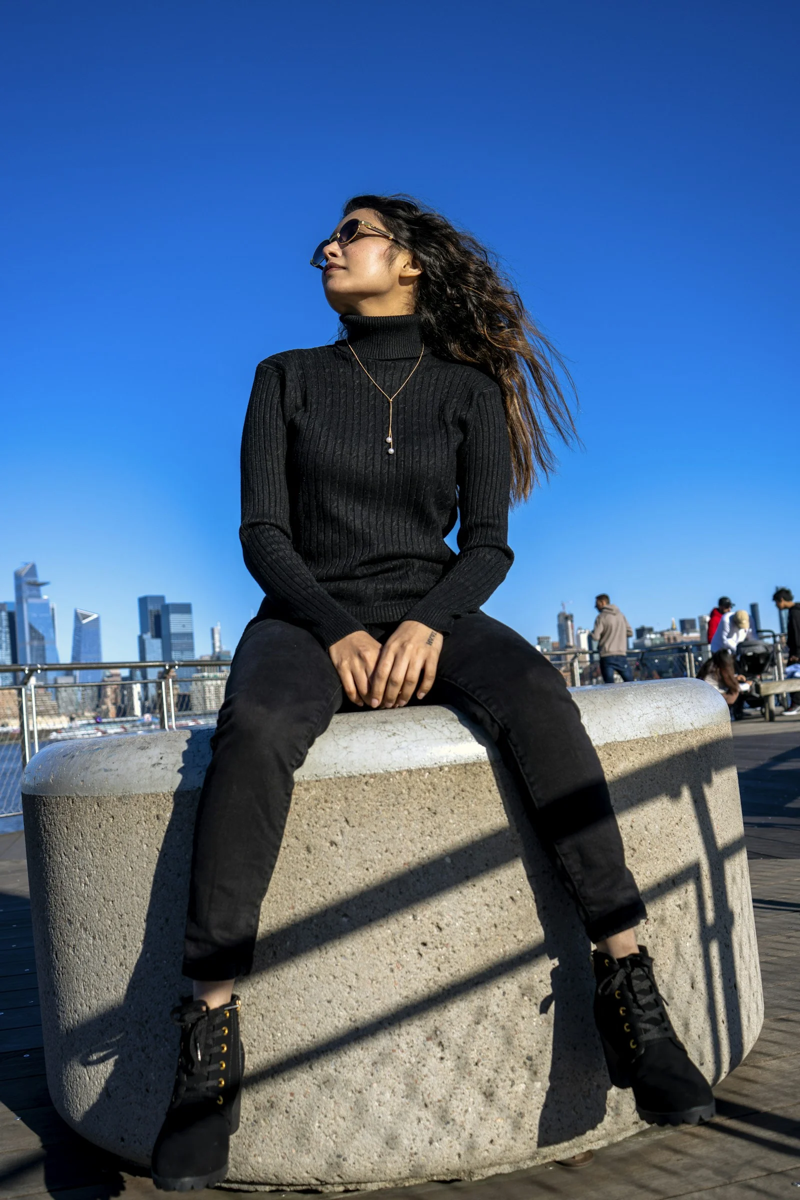 a woman sitting on top of a cement block
