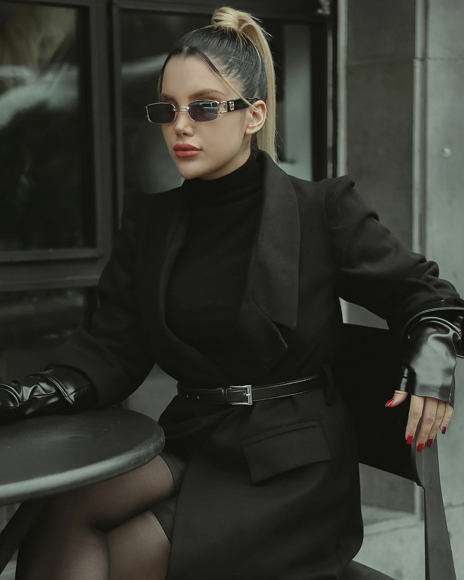 a woman sitting at a table wearing a black outfit