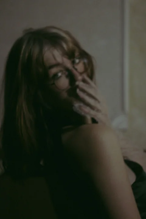 A woman with glasses is talking on a cell phone