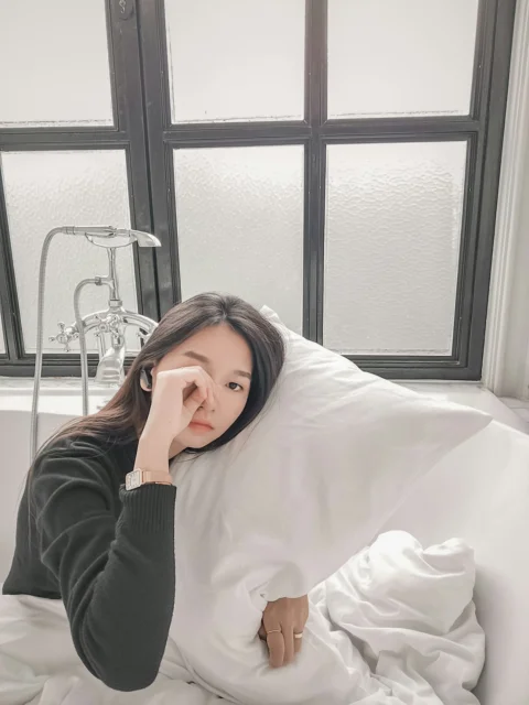 一名女人躺在浴缸裡，頭上蓋著毯子