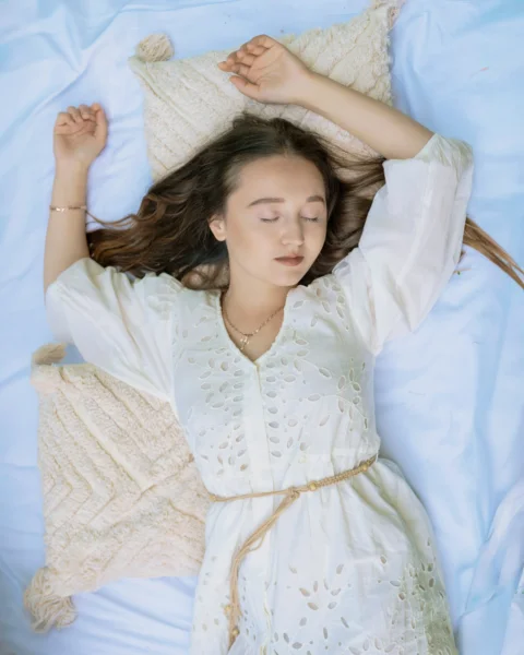 一名女子躺在床上閉著眼睛