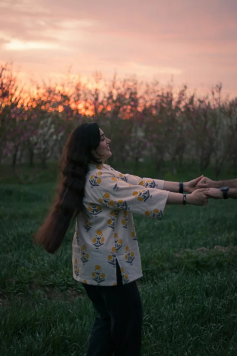 a woman holding a frisbee in a grassy field