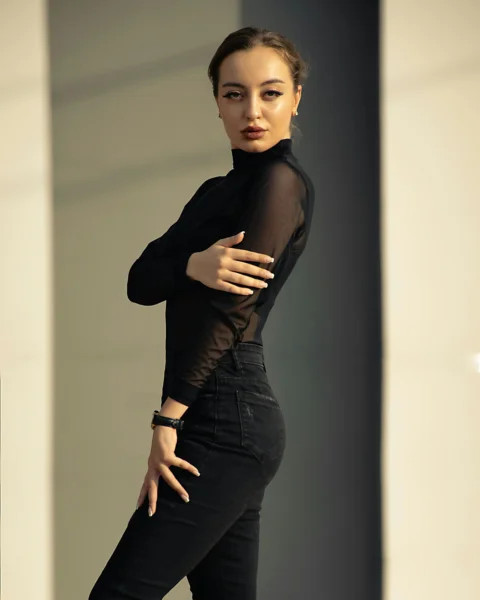 A woman is posing for a picture in a black outfit