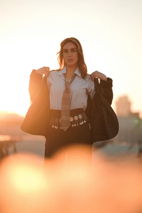 Woman in suit jacket and tie at sunset