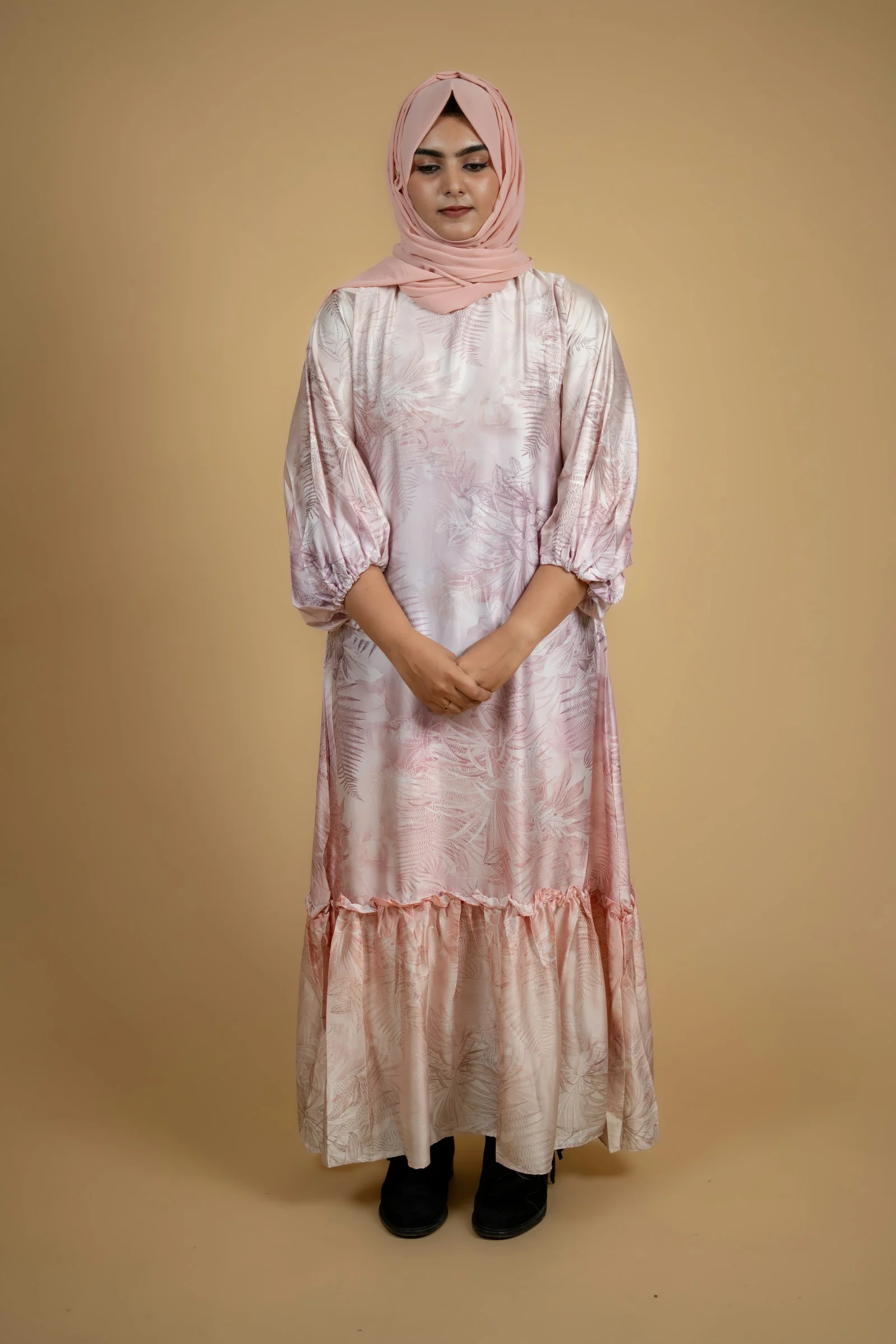 a woman wearing a pink dress and a headscarf