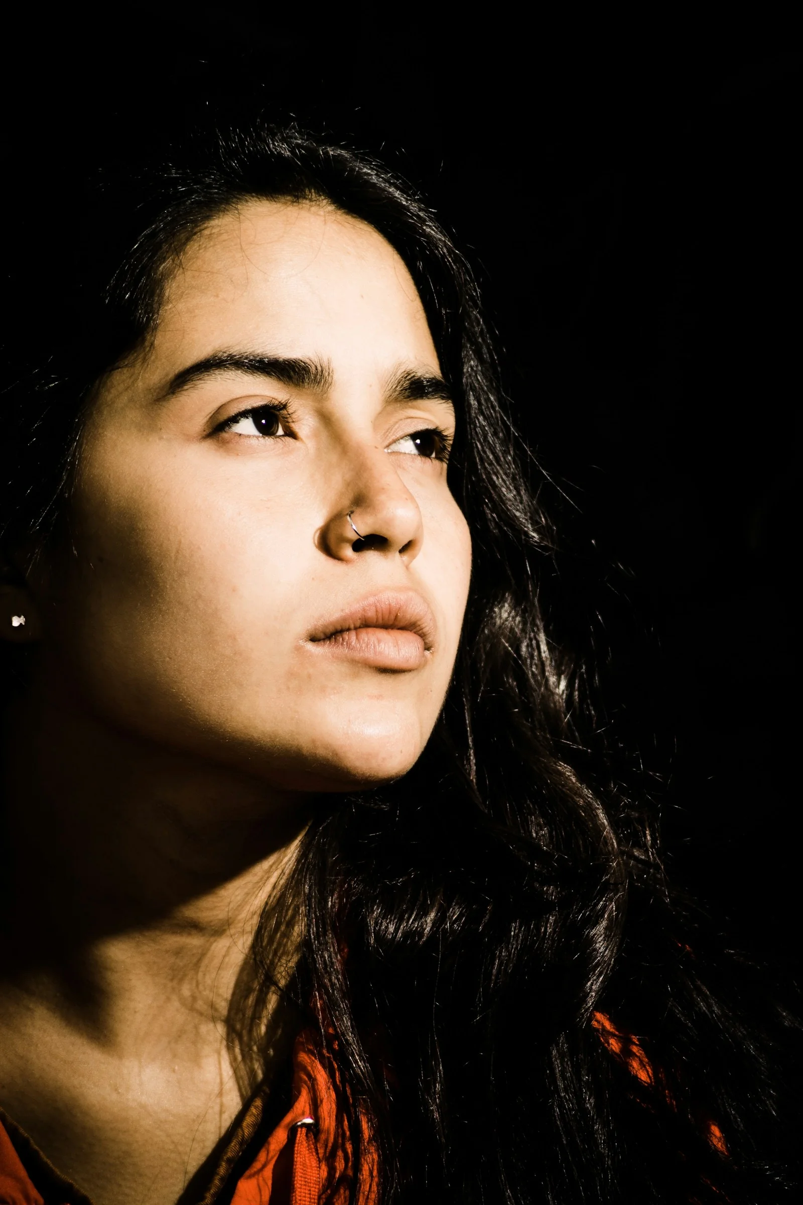 woman with black hair wearing orange shirt
