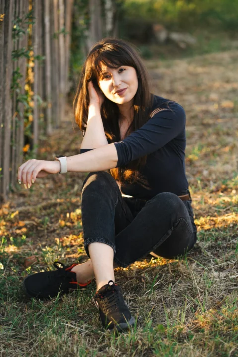 A woman sits relaxed, smiling at the camera