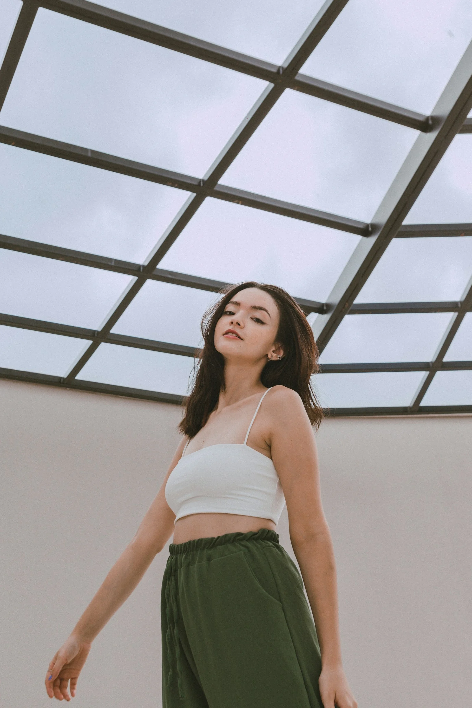 a woman in a white top and green pants