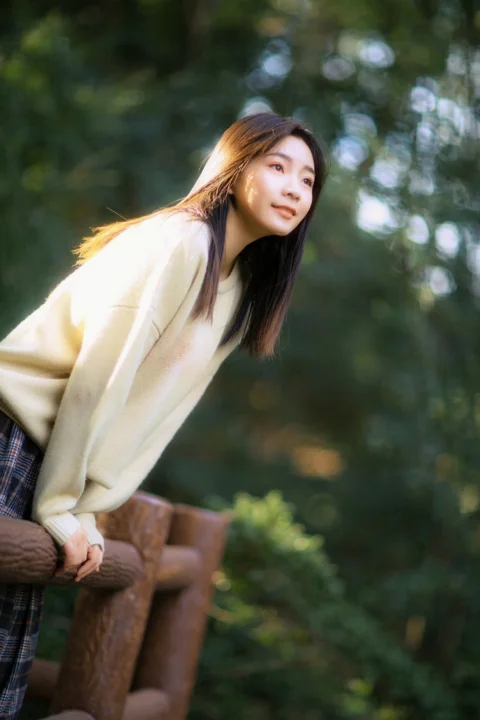 woman in yellow cardigan sitting on brown wooden bench