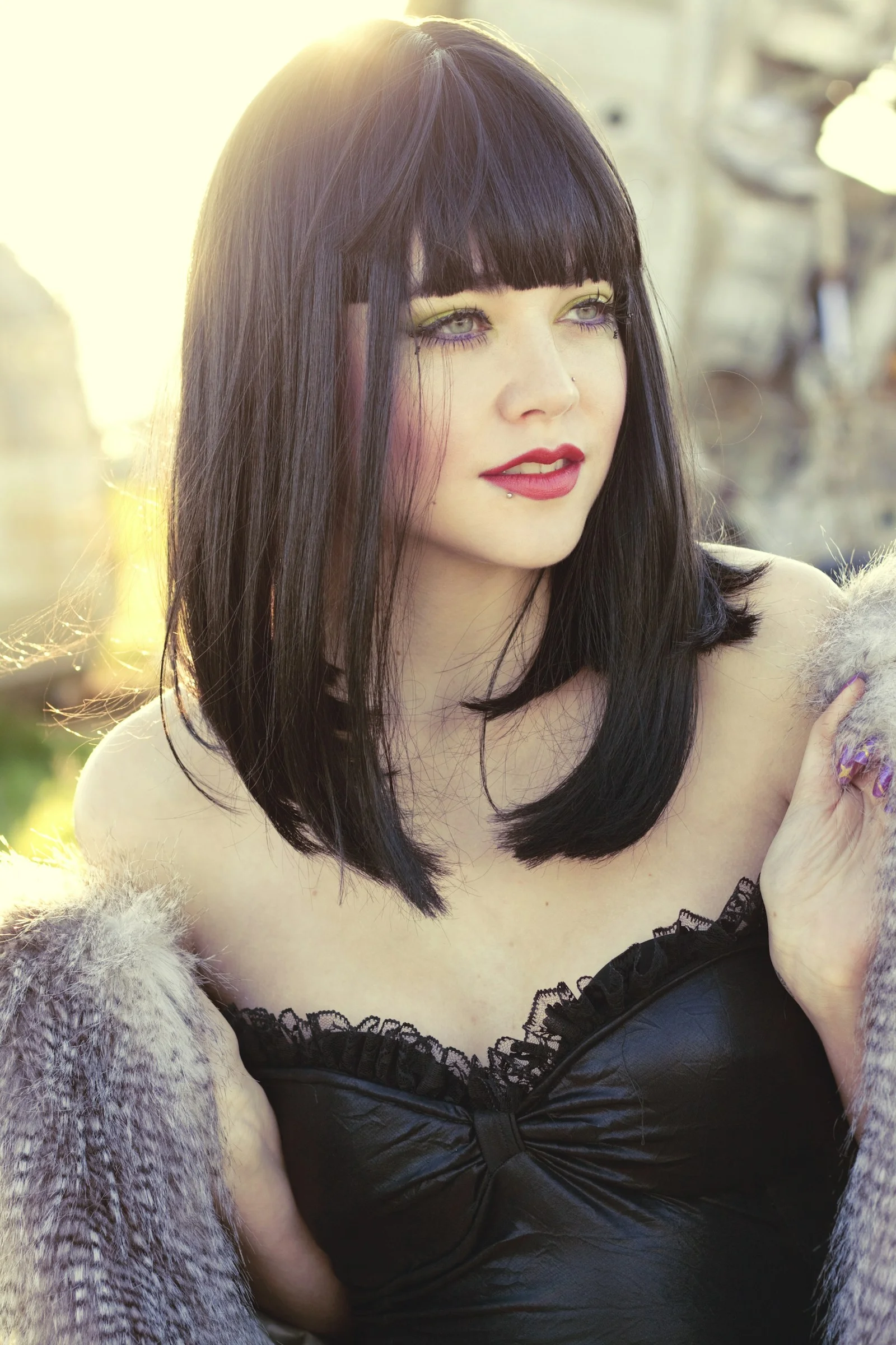 a woman in a black dress and fur coat