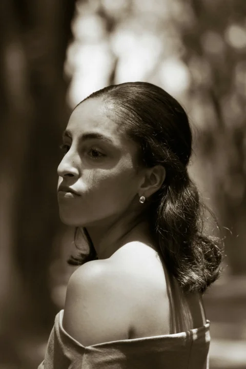 Sepia-toned woman looking over her shoulder with soft lighting