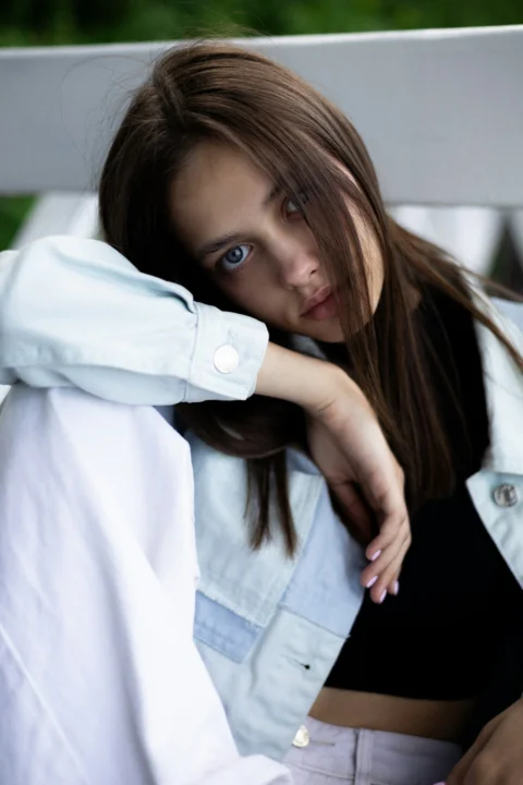 A young woman poses, looking pensively at the camera