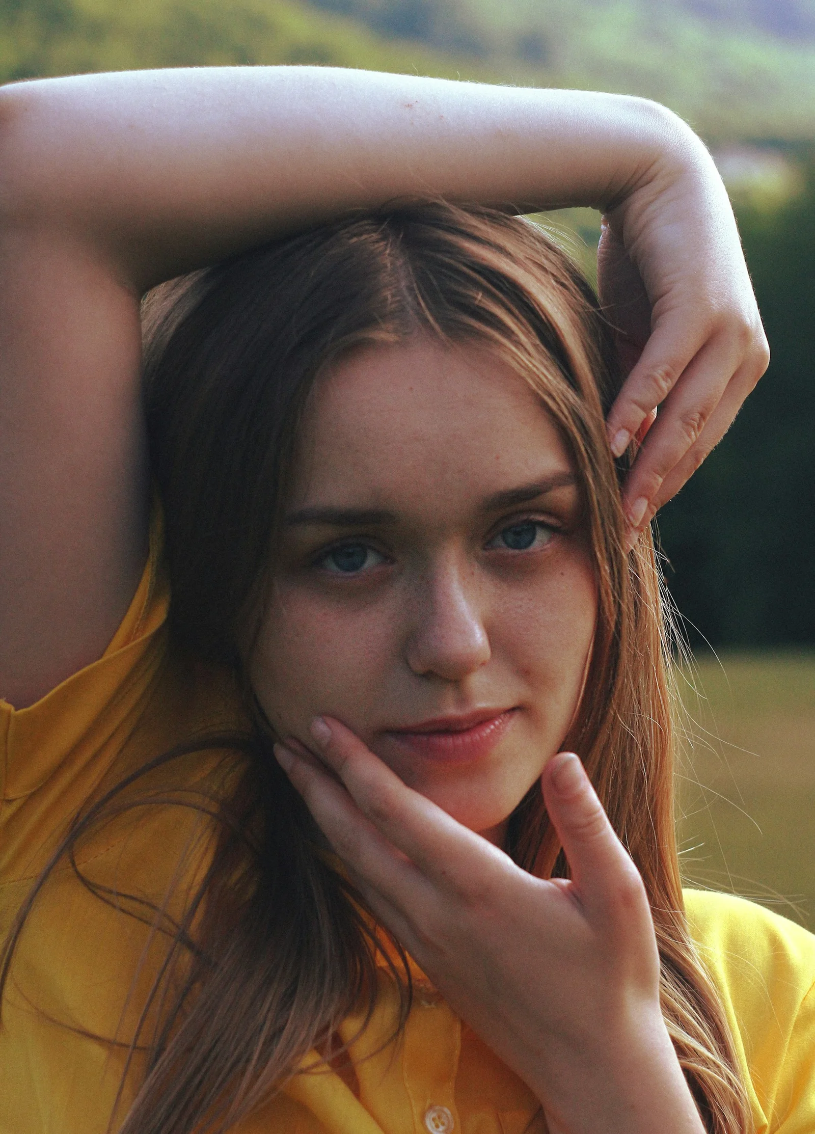 Young woman with long blonde hair in yellow shirt