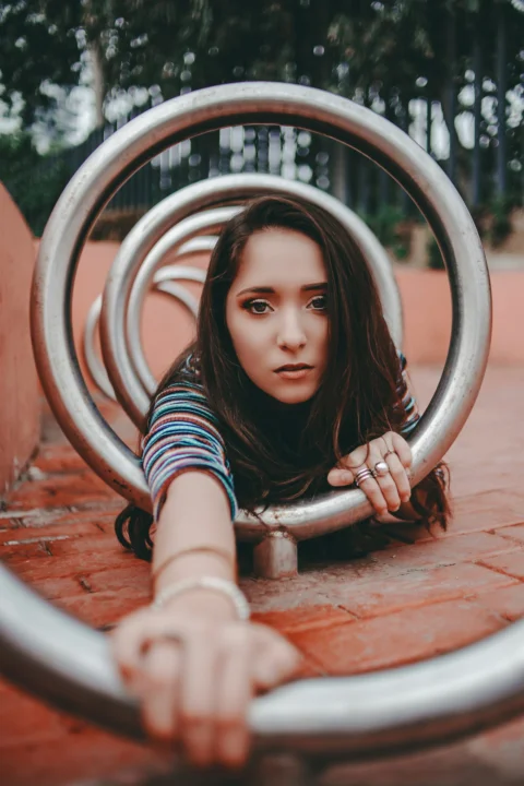 在圆形灰色金属杆上爬行的女人