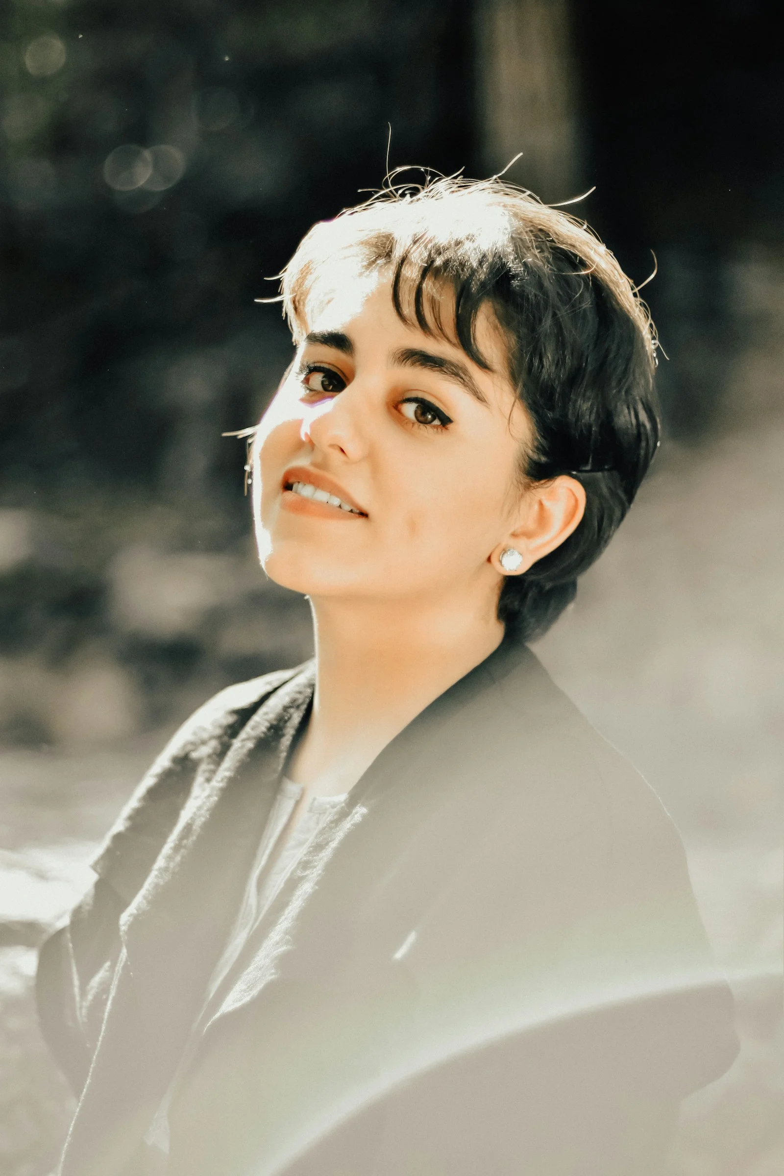 A woman with short hair and a black shirt
