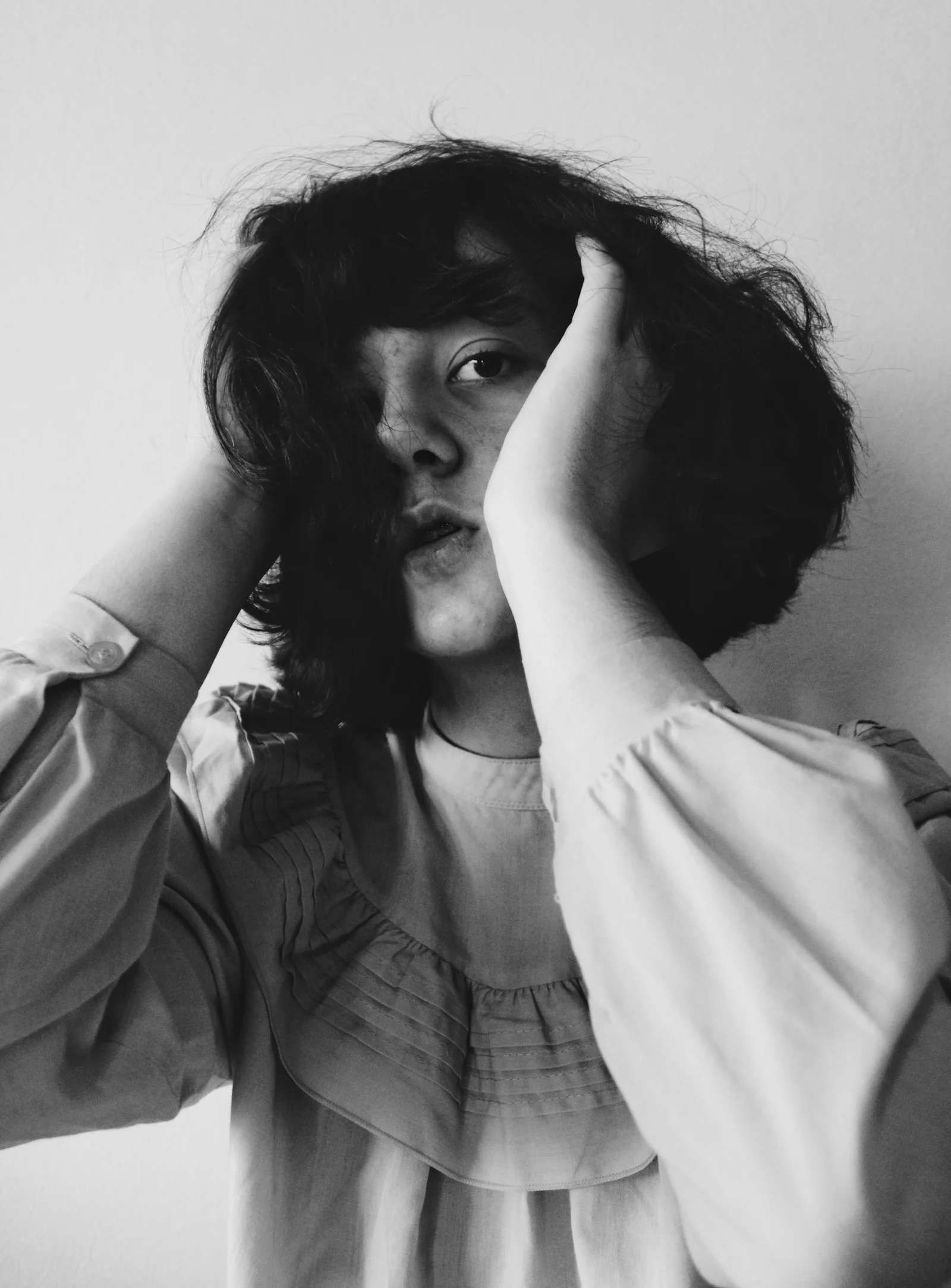 a woman holding her hair up to her face